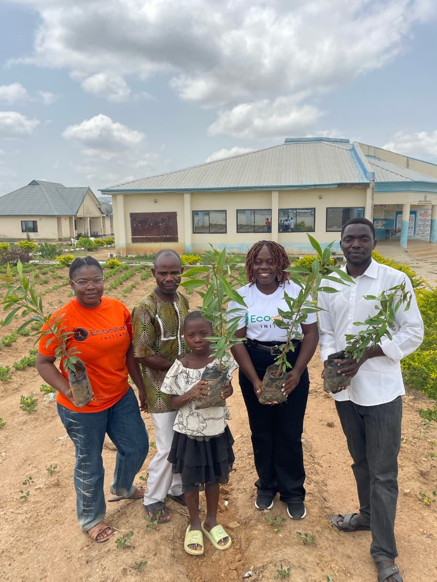Community members holding tree saplings